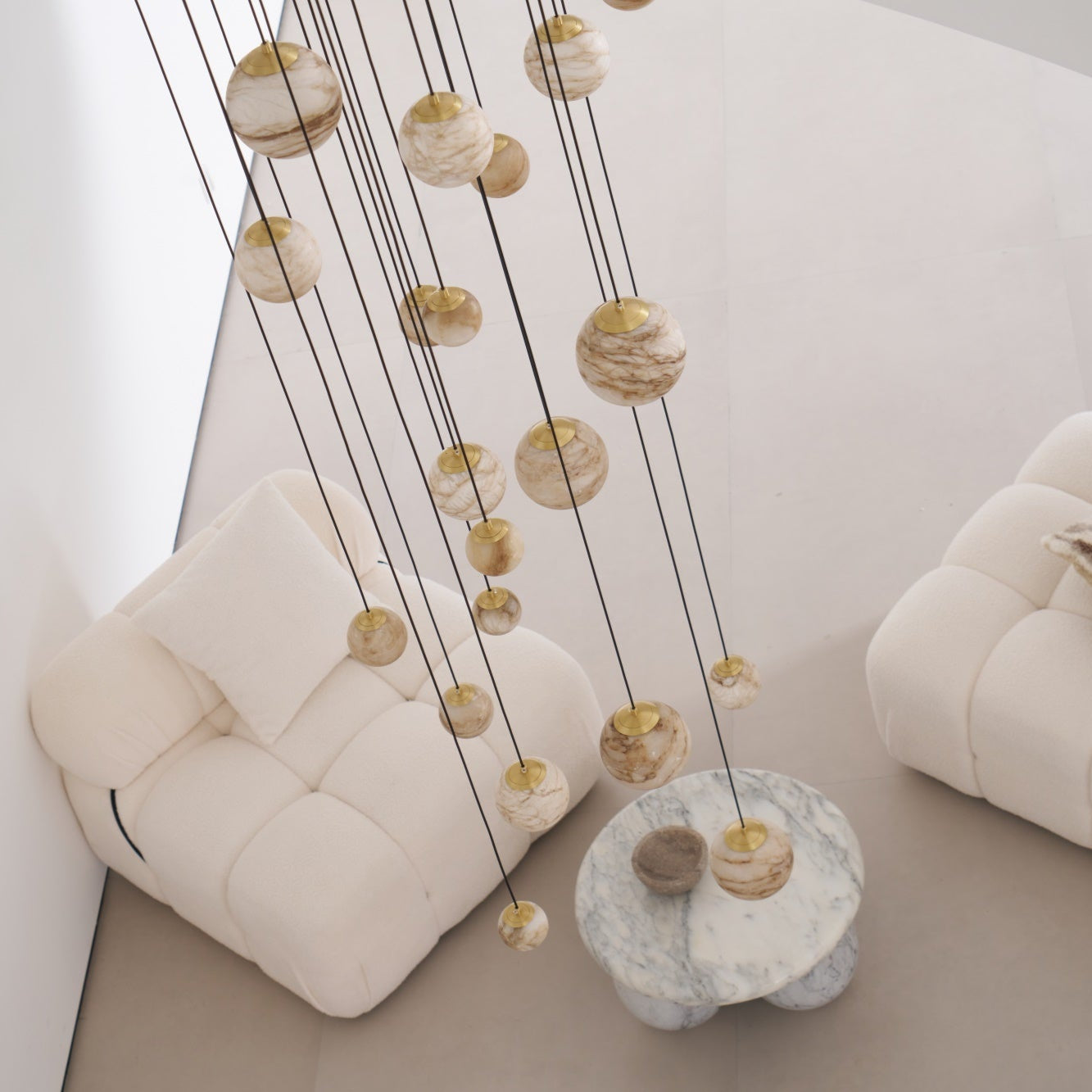 The chandelier unlit in daylight, its pale alabaster globes reading as veined cream stone from above.