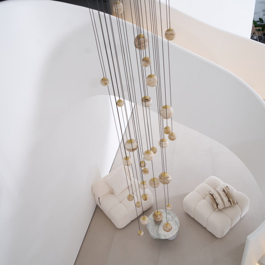 Looking down the spiral stairwell at the unlit chandelier falling the full height to the seating below.