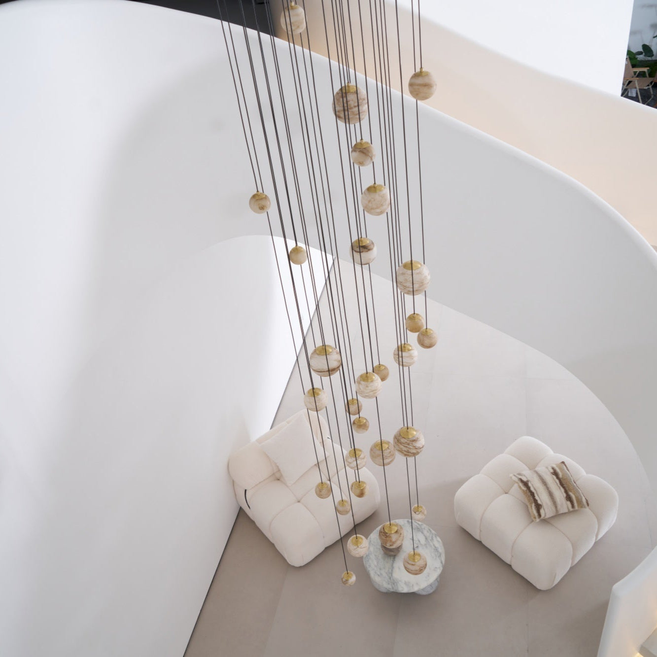 Looking down the spiral stairwell at the unlit chandelier falling the full height to the seating below.