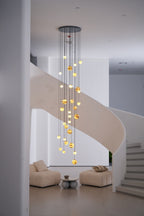 Wider daylight framing with the lit chandelier centred above two low boucle lounge chairs.