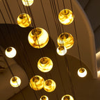 Close-up from below of the lit globes, showing the brass caps and cloudy veining inside the alabaster.