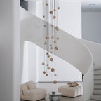 Unlit daytime view of the full cascade hanging against the white curve of the spiral staircase.