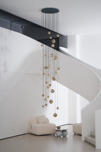 The unlit chandelier hung from a dark ceiling plate, globes staggered down the height of the stairwell.