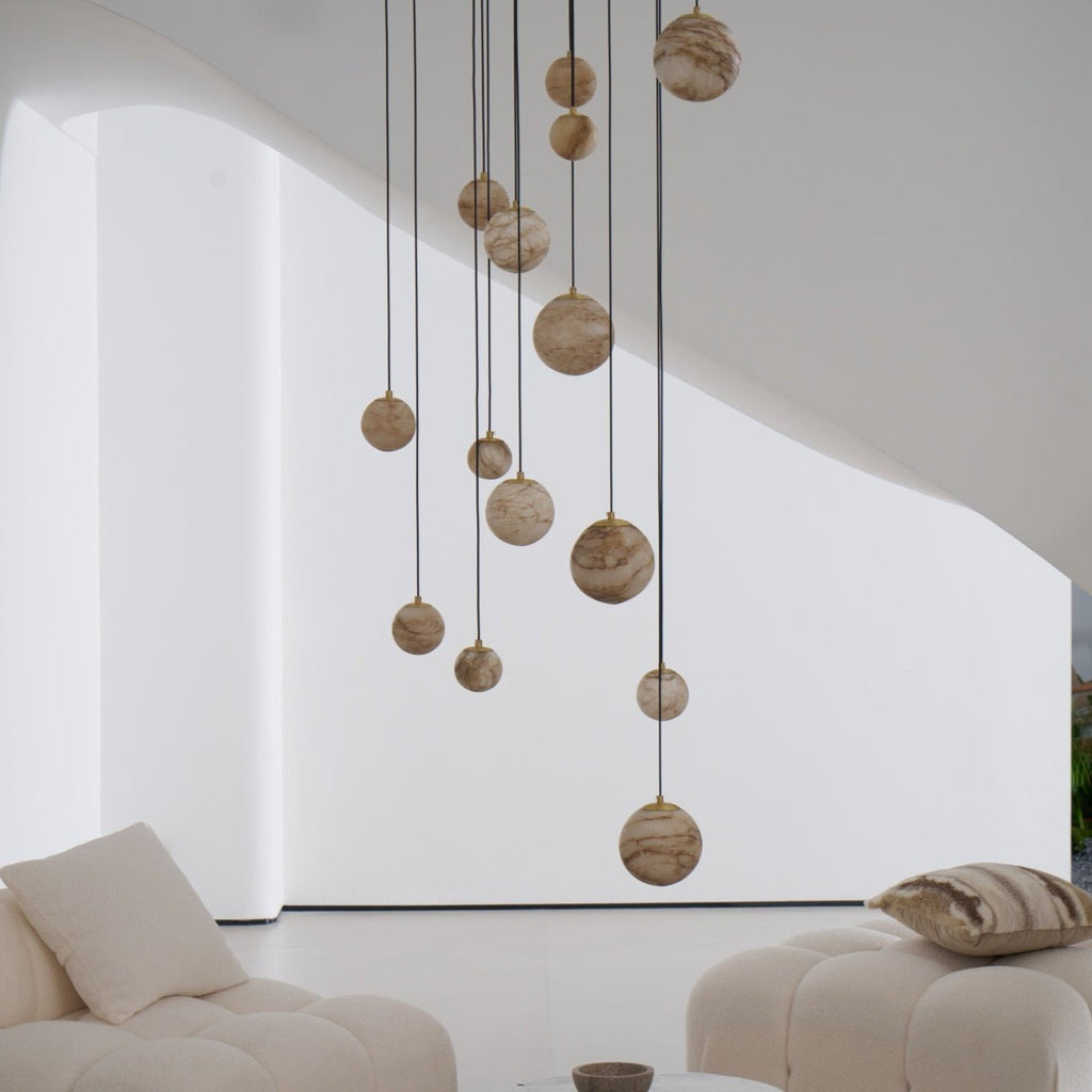 Unlit alabaster globes in varying sizes, seen against a plain white wall above the lounge seating.