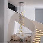 Daylight room view with the chandelier lit and the spiral stair's illuminated treads to the right.