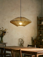 In a rustic dining room with pampas grass in a clay vase, this Clérachic pendant glows above a long wood table.