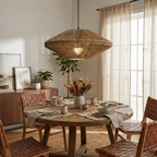 Framed by sheer curtains, this Clérachic pendant lights a round dining table set beside a wood sideboard.