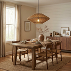 In a shiplap-walled dining room, this Clérachic pendant hangs above a table set for four near a vase of dried branches.