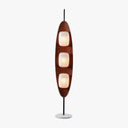 Clérachic teak-finish floor lamp with three stacked white glass shades, photographed full length against a plain studio backdrop.