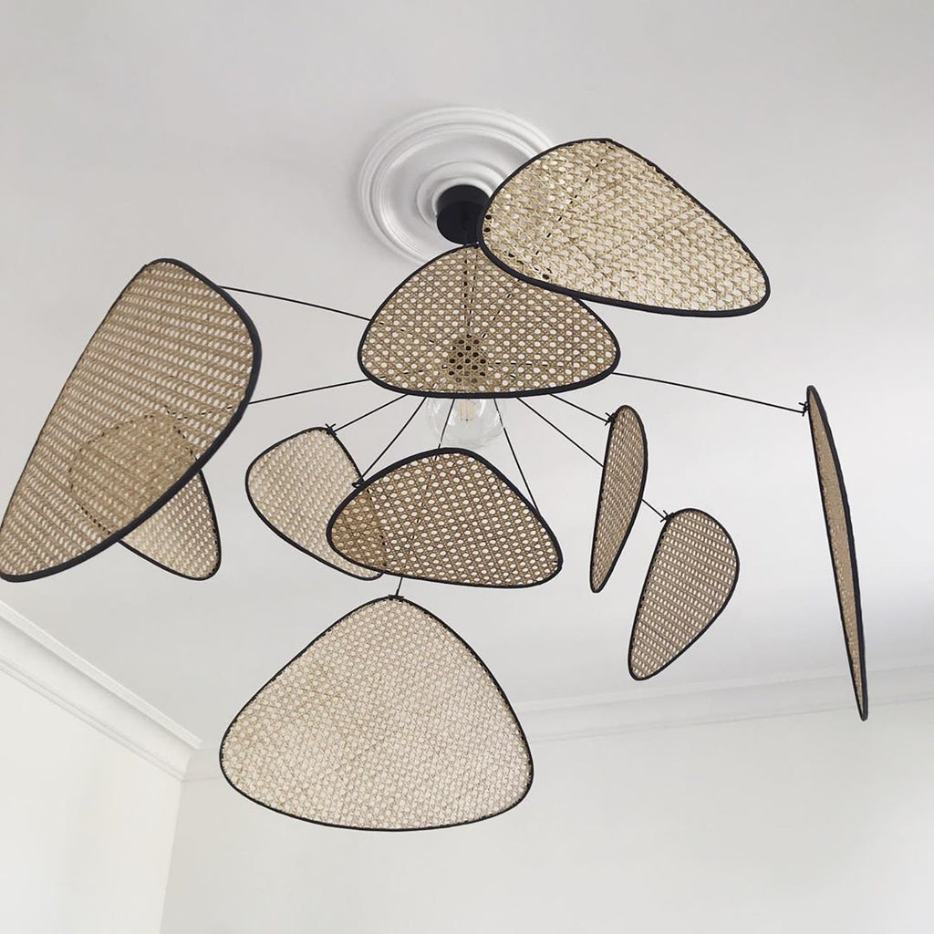 A close ceiling view of this Clérachic pendant shows its black wire frame fanned beneath a plain white ceiling rose.