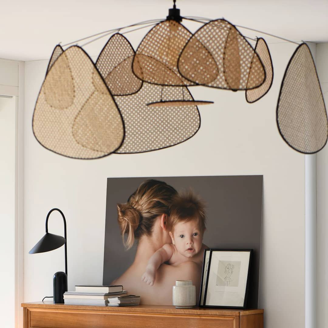 A console table dressed with books and a framed photograph sits beneath this Clérachic pendant.