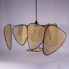 A close studio view on a lilac backdrop shows the bamboo weave texture across this Clérachic pendant's paddles.