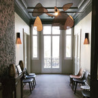 Beneath a green-painted ceiling, this Clérachic pendant hangs in a tall entry hall with French doors and wood chairs.