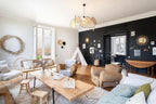 This Clérachic pendant hangs high above a living room furnished with a canvas teepee and a sunburst mirror.