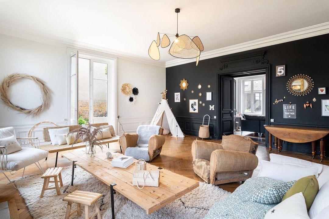 This Clérachic pendant hangs high above a living room furnished with a canvas teepee and a sunburst mirror.