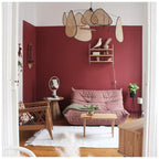 Deep red walls and a pink sofa furnish the room where this Clérachic pendant hangs beside a small curio shelf.