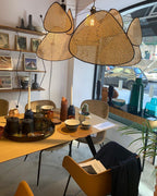 This Clérachic pendant hangs above a shop dining table set with ceramics, shelves of books behind.