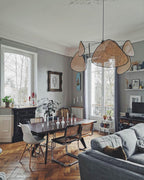 Tall windows light the dining room where this Clérachic pendant hangs above a dark wood table.