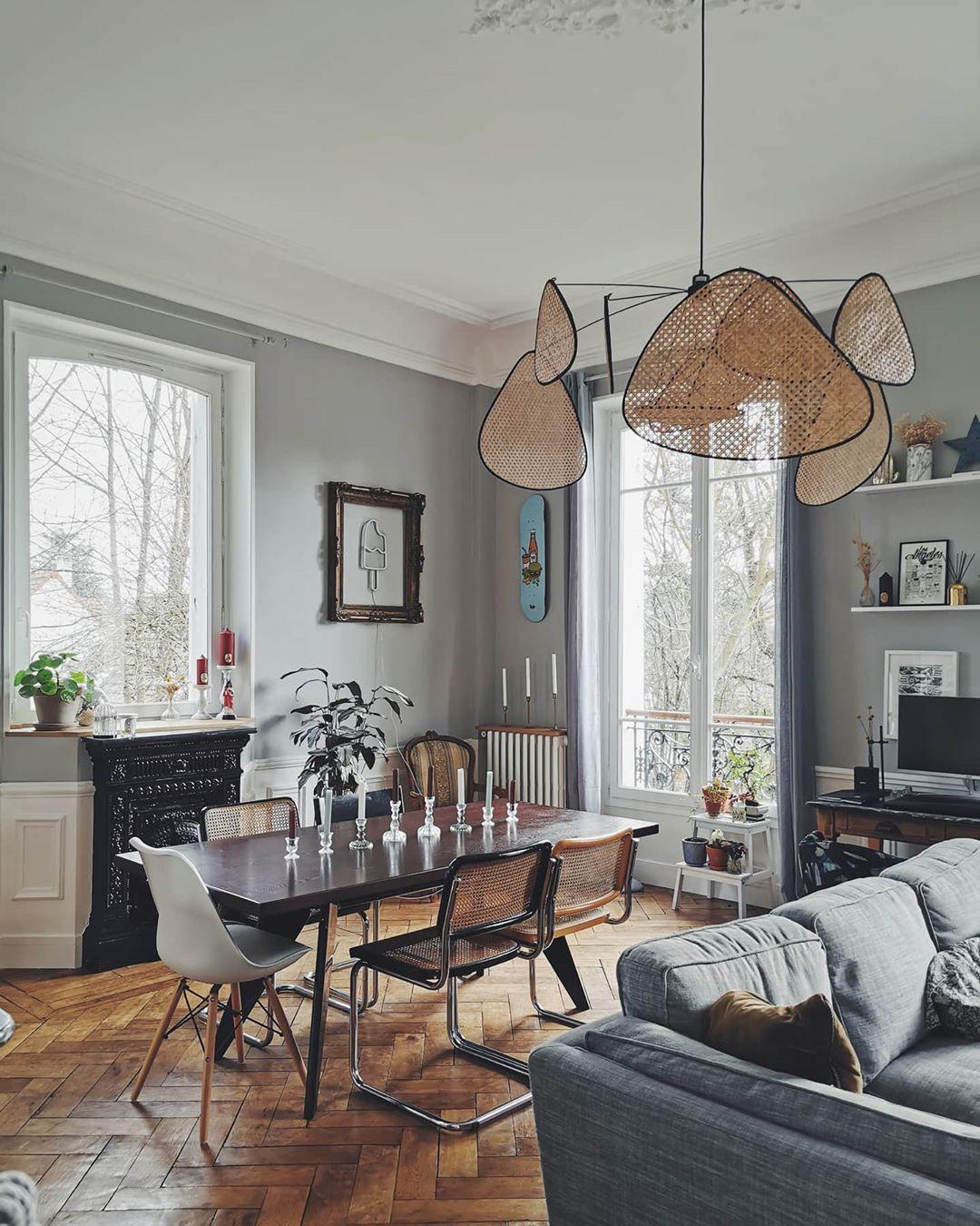 Tall windows light the dining room where this Clérachic pendant hangs above a dark wood table.