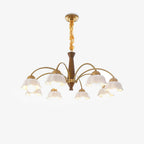 Midcentury brass chandelier with opaline ceramic shades lit warmly