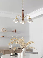 Brass chandelier with frosted ceramic shades casting a warm glow