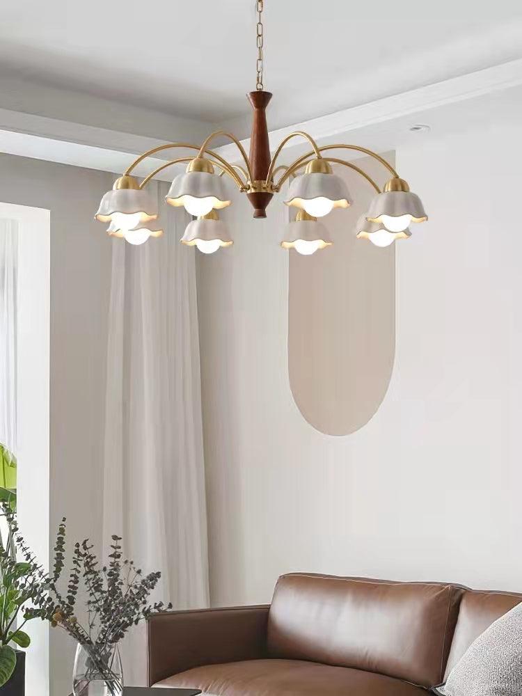 Brass and walnut chandelier lit warmly in a living space