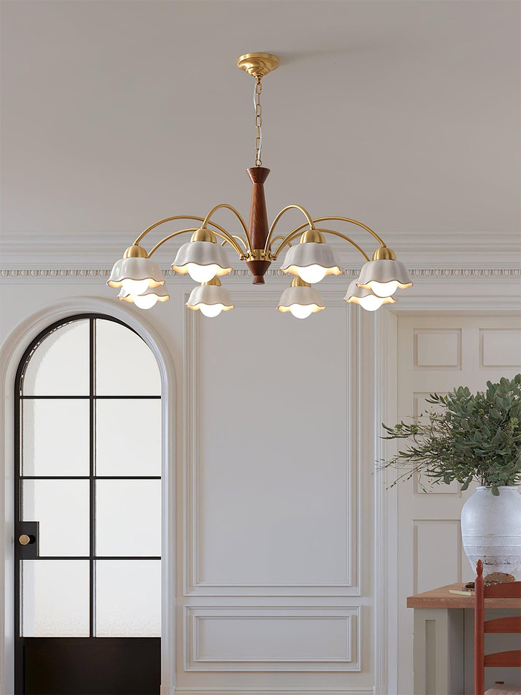 Swedish modern brass chandelier glowing above a dining table