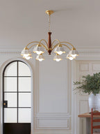 Swedish modern brass chandelier glowing above a dining table