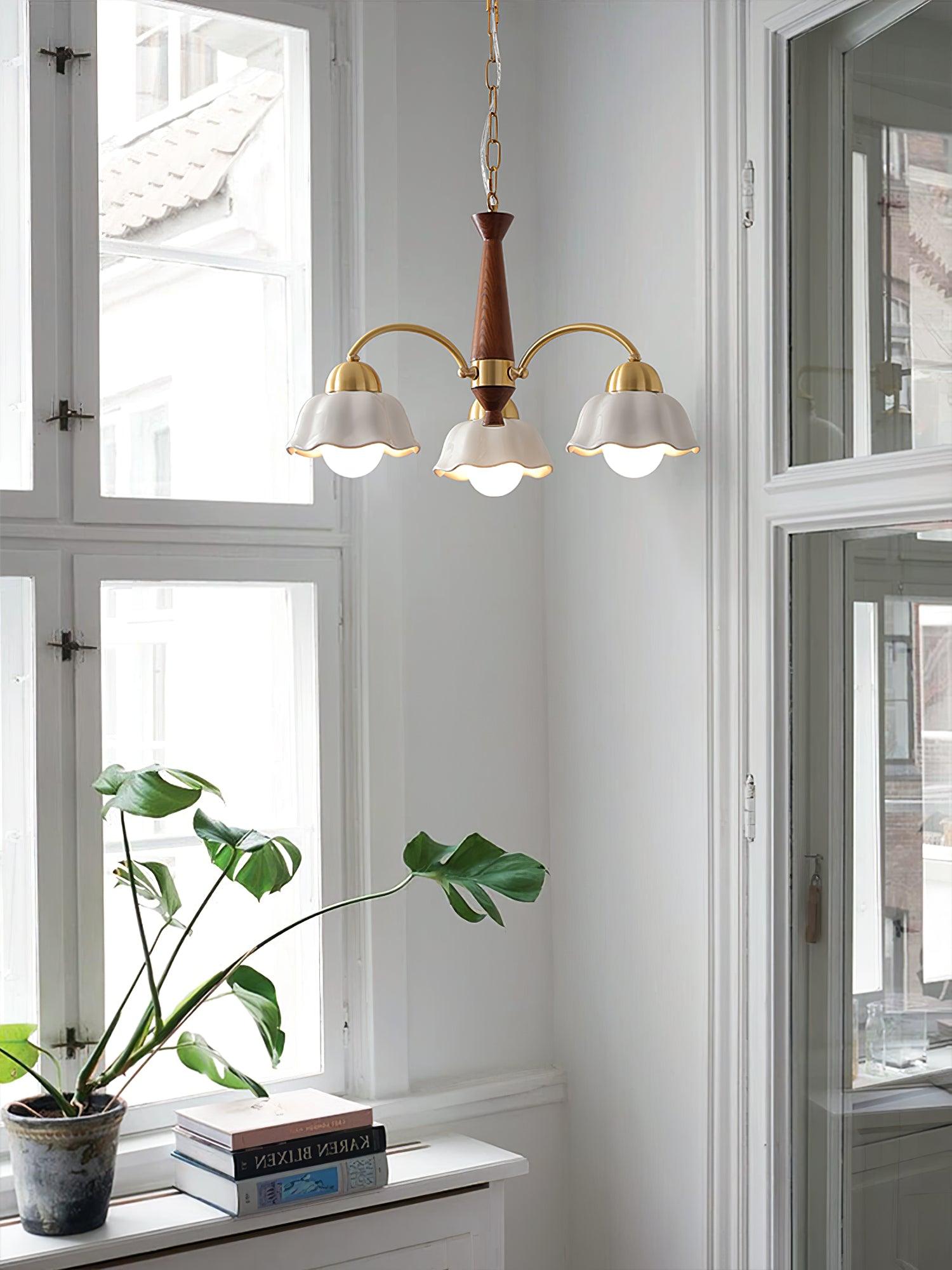 Walnut and brass chandelier with frosted shades over a dining table
