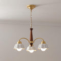 Brass and walnut chandelier with opaline ceramic shades glowing warmly