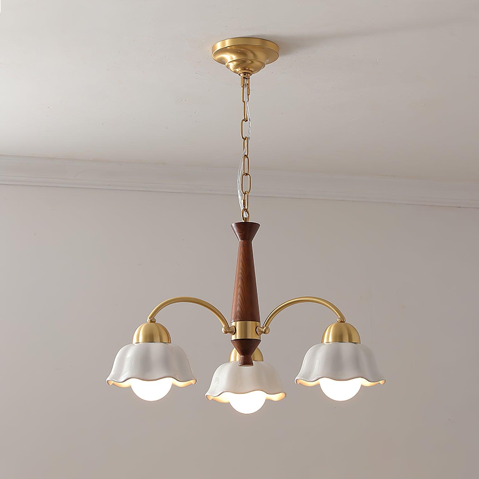 Brass and walnut chandelier with opaline ceramic shades glowing warmly