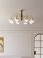 Brass and walnut chandelier with opaline shades against a warm wall