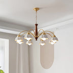 Brass and walnut chandelier with white ceramic shades glowing softly