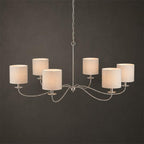 Studio view of this Clérachic chandelier in satin nickel, fitted with six white drum lampshades.