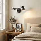 Gold wall sconce arm and white shade against a plain backdrop