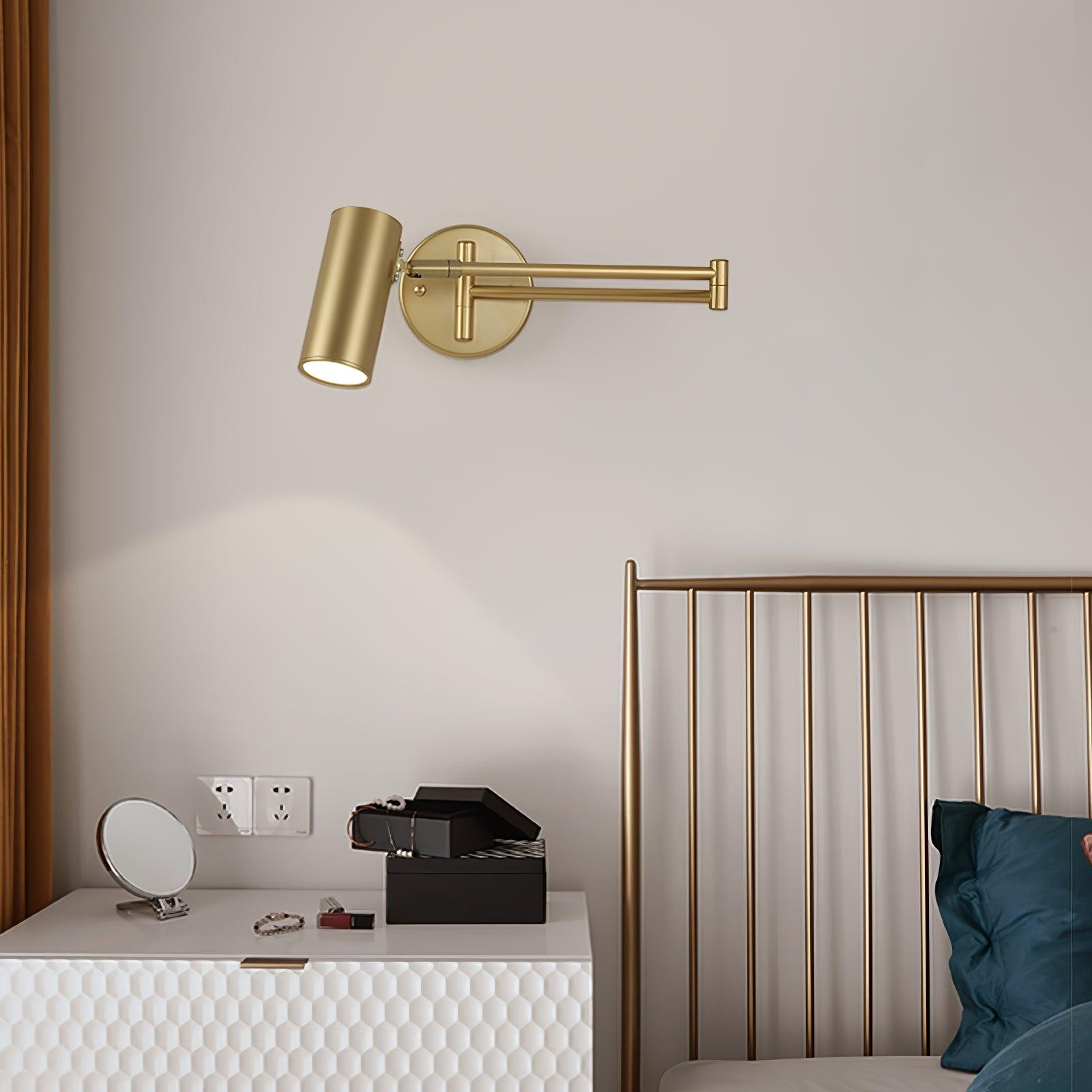 Gold swing arm wall sconce on a clean studio background