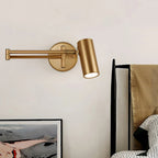 Wall sconce arm extended over a bedside reading spot