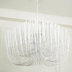 Wood rod chandelier illuminated above a long dining table