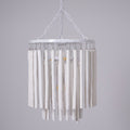 Wood rod chandelier suspended over a dining table in a bright room