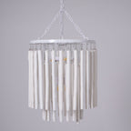 Wood rod chandelier suspended over a dining table in a bright room