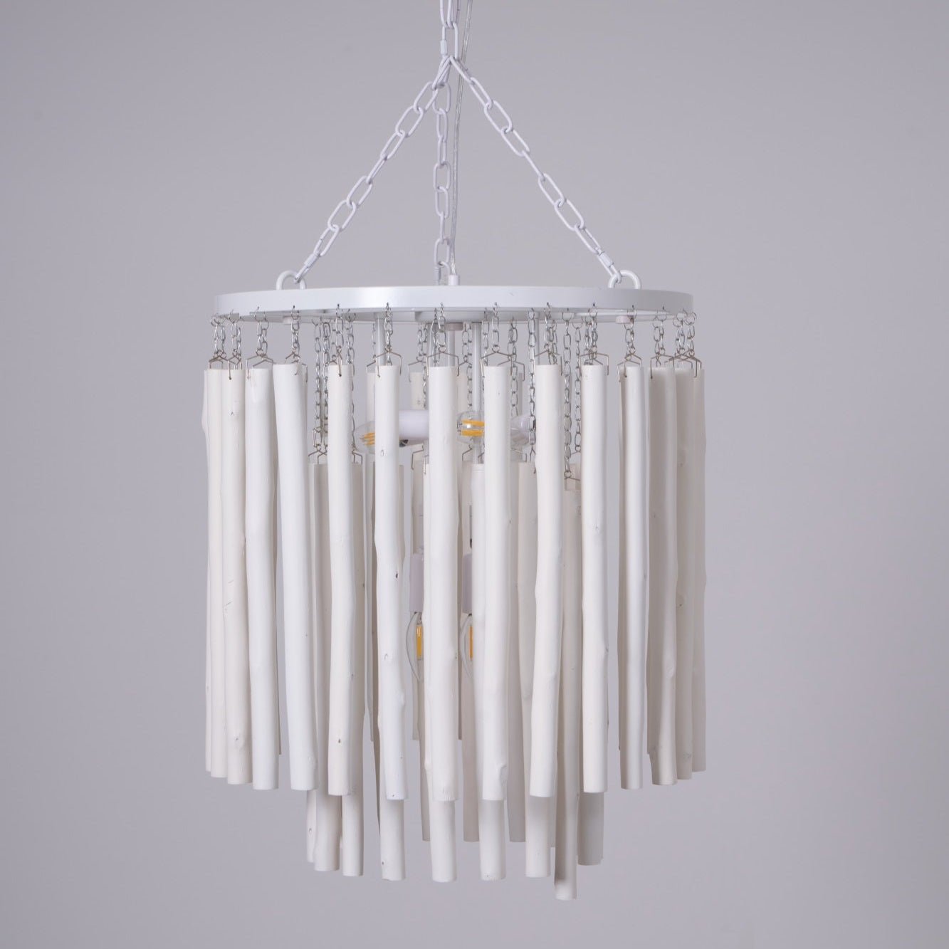 Wood rod chandelier suspended over a dining table in a bright room