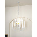 Natural wood chandelier with layered rods lit warmly at dusk