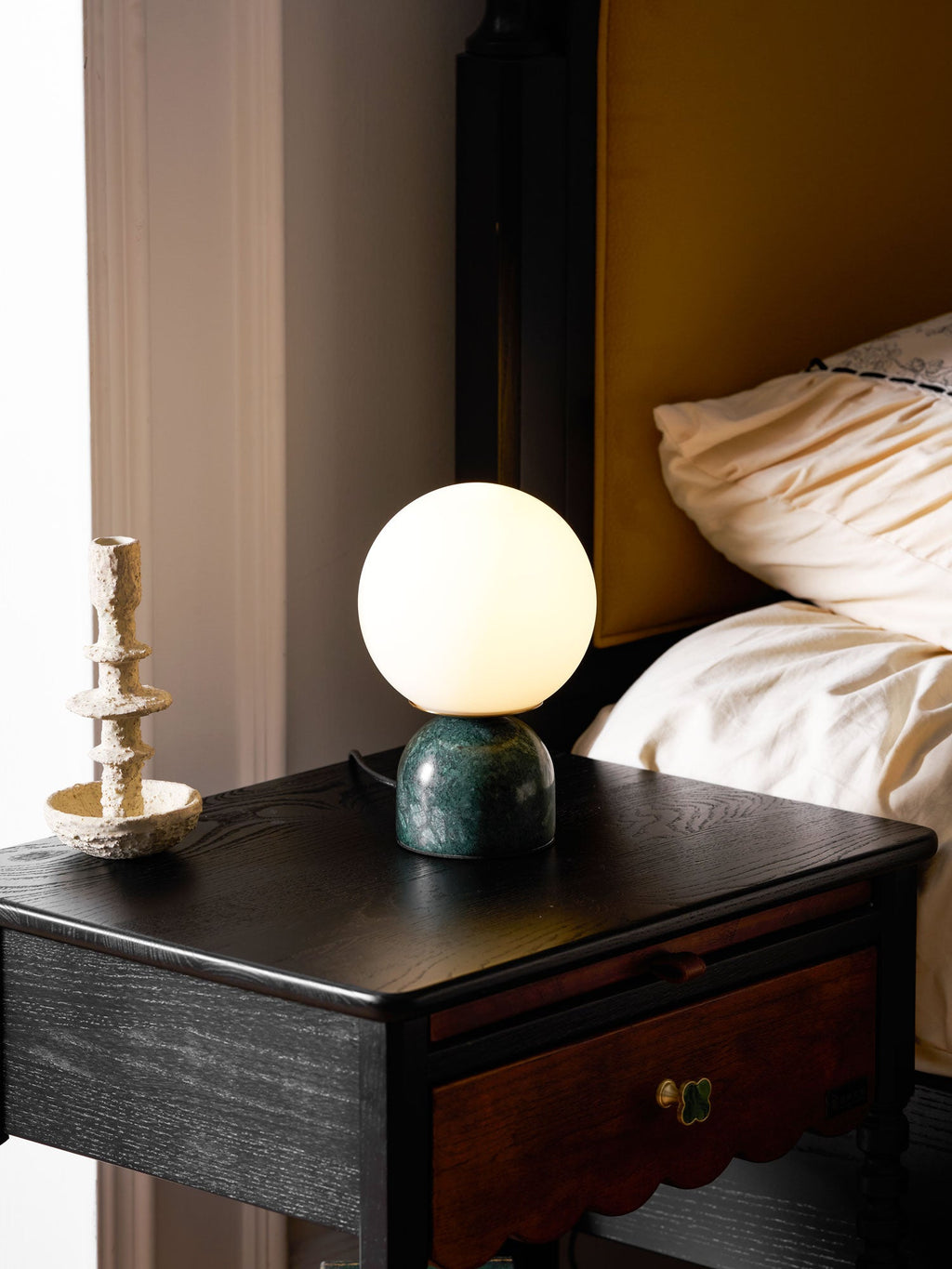 Glass orb table lamp glowing softly in a quiet corner