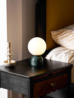 Glass orb table lamp glowing softly in a quiet corner