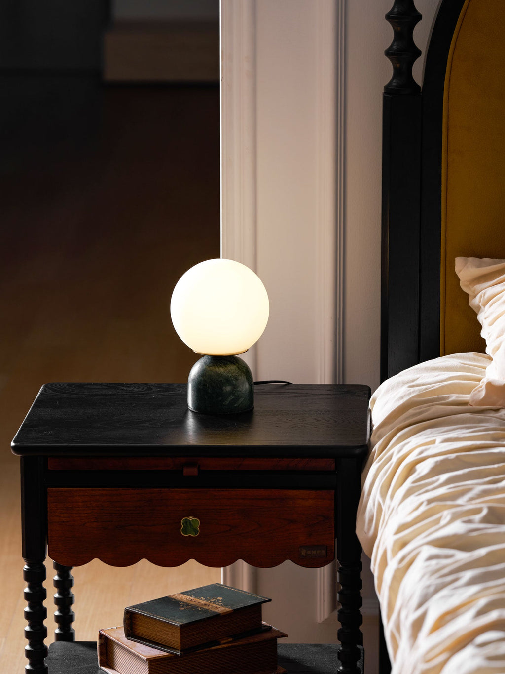 Marble table lamp with white glass orb in a styled setting