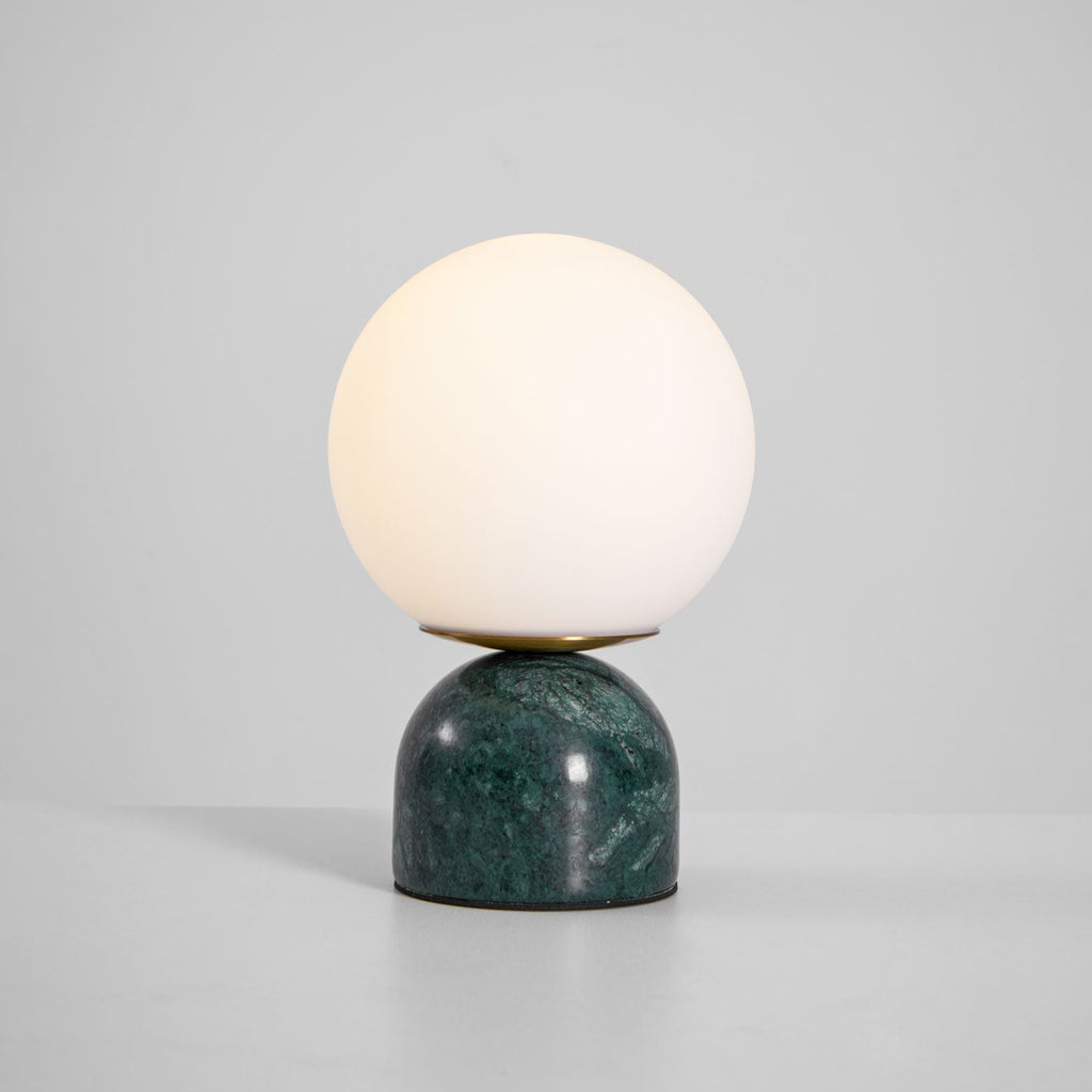 Sylas marble table lamp lit beside a framed photo
