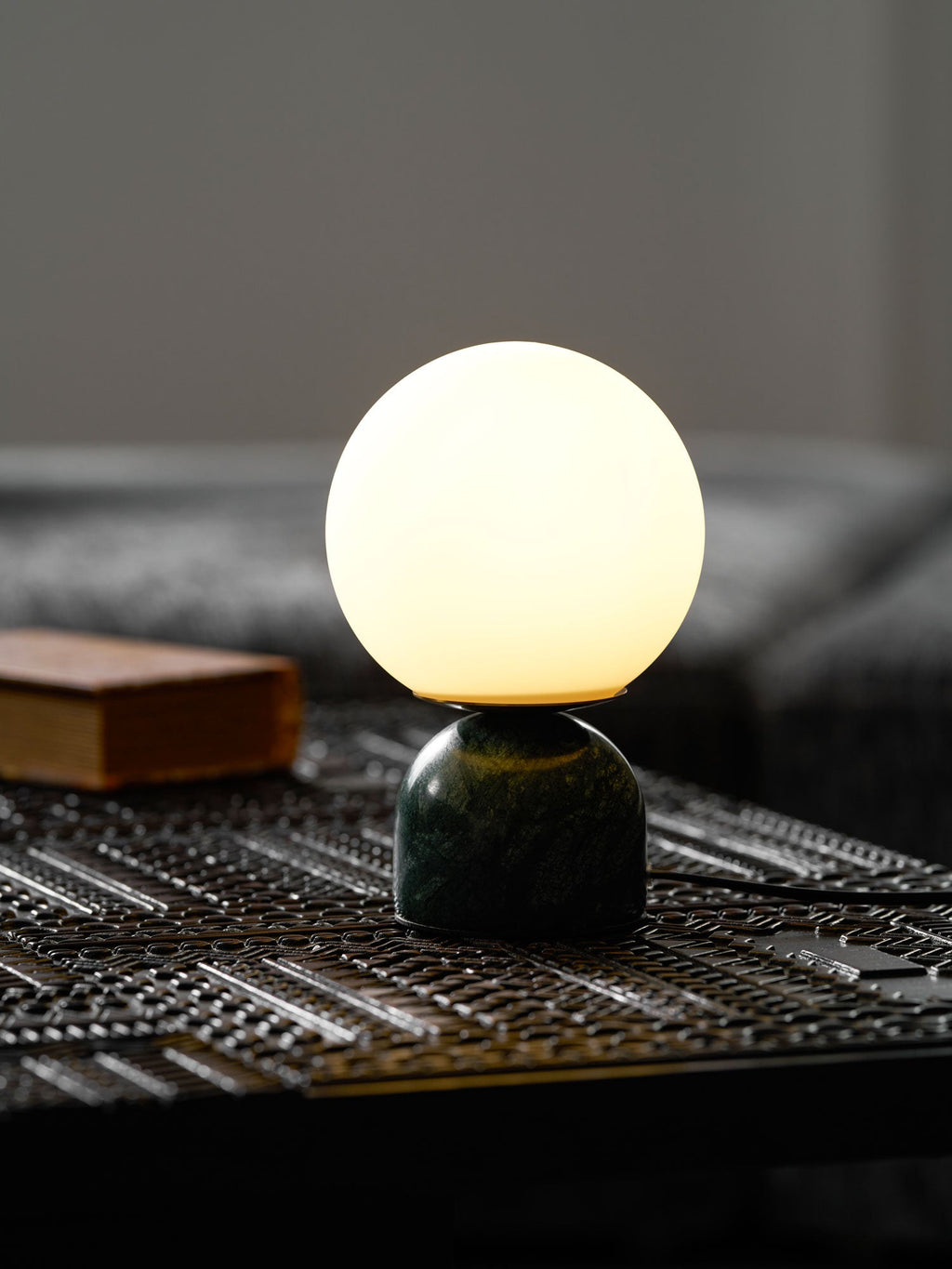 Marble table lamp with luminous orb in a warm living space