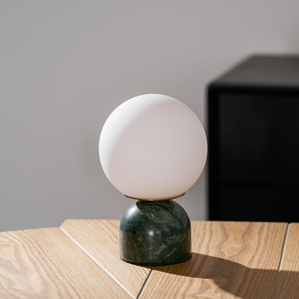Marble base lamp with white glass orb against a soft backdrop