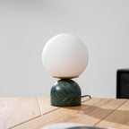 Sylas marble table lamp with white globe in a minimalist room
