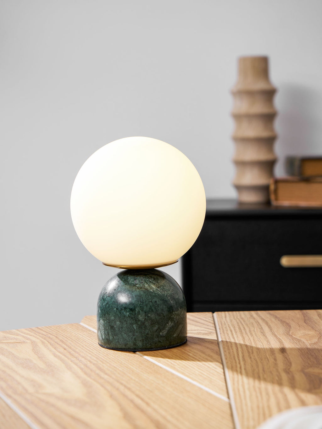 White glass orb lamp on a marble base in a bright interior
